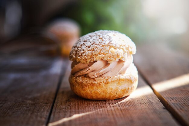 Deliziose torte sandwich con crema pasticcera e zucchero a velo sul tavolo di legno. Servizio fotografico del primo piano.