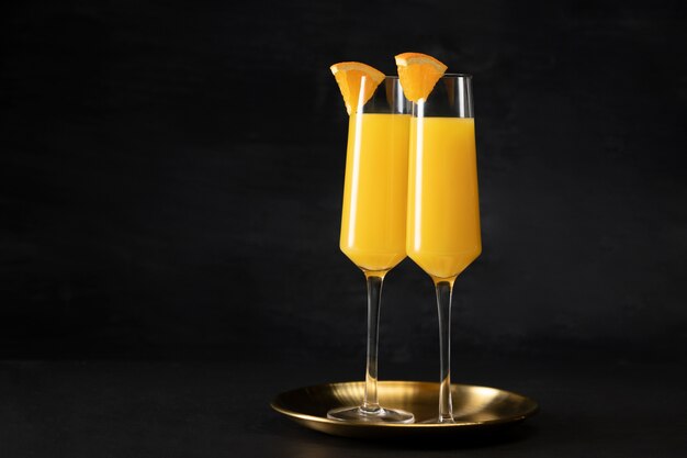 Deliziosi bicchieri da cocktail in mimosa con fettine d'arancia