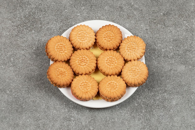 Deliziosi biscotti ripieni di crema sul piatto bianco