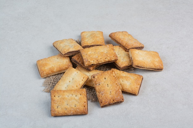 Deliziosi cracker dolci su tela di sacco su sfondo bianco. Foto di alta qualità