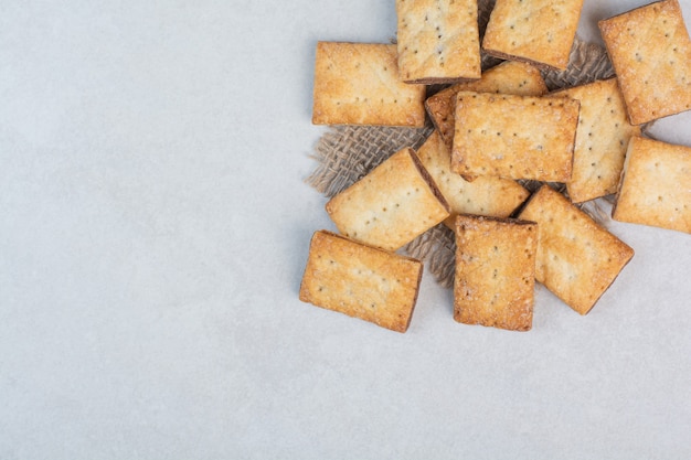 Deliziosi cracker dolci su tela di sacco su sfondo bianco. Foto di alta qualità