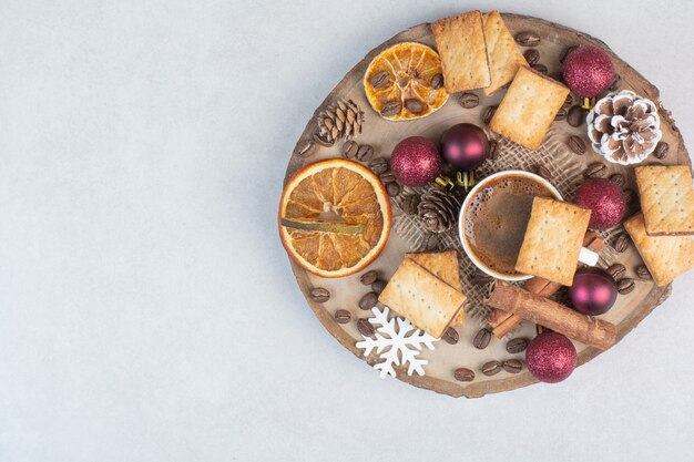 Deliziosi cracker e tazza di caffè sul piatto di legno. Foto di alta qualità