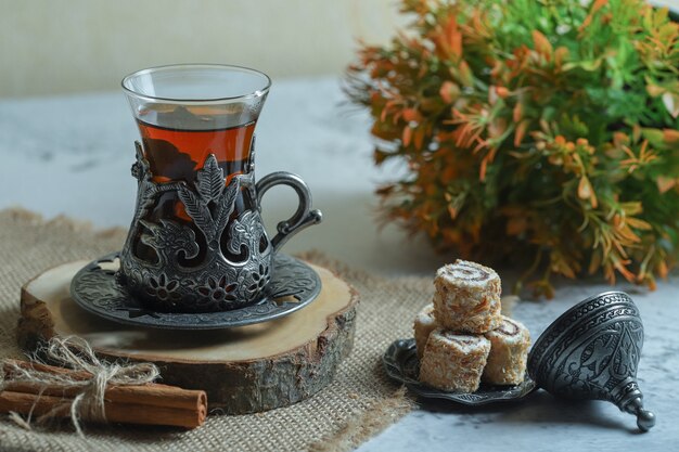 Deliziosi dessert lokum e bicchiere di tè sulla superficie della pietra.