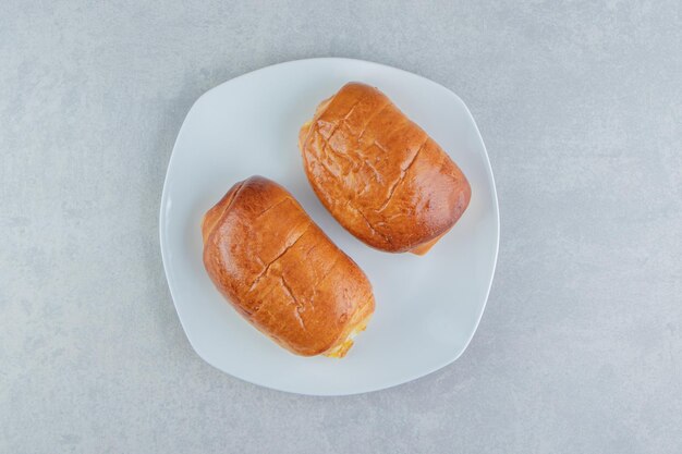 Deliziosi pasticcini con salsicce sul piatto bianco.