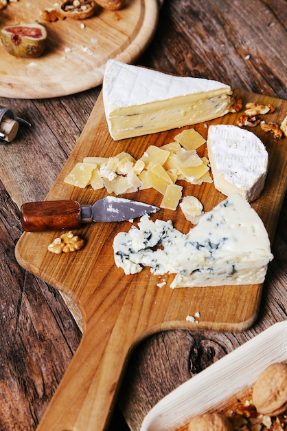 Deliziosi pezzi di formaggio in tavola di legno