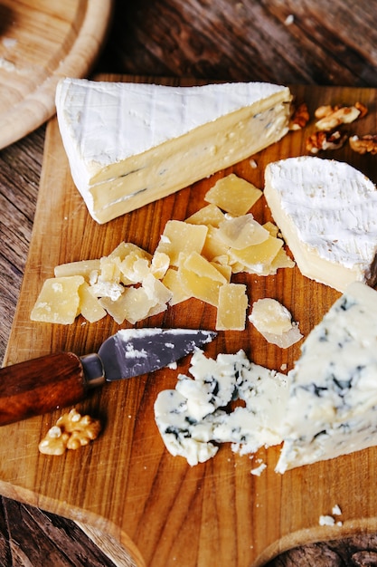 Deliziosi pezzi di formaggio in tavola di legno