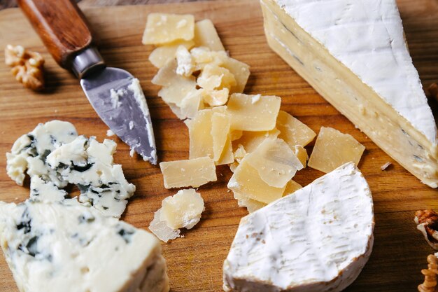 Deliziosi pezzi di formaggio in tavola di legno