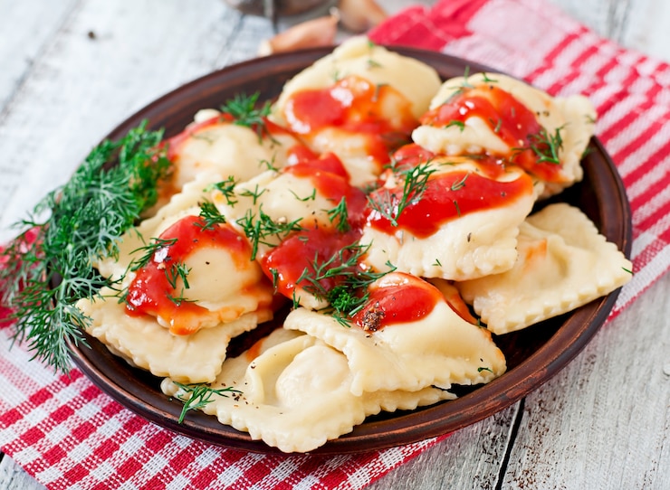 Foto gratuito deliziosi ravioli con salsa di pomodoro e aneto