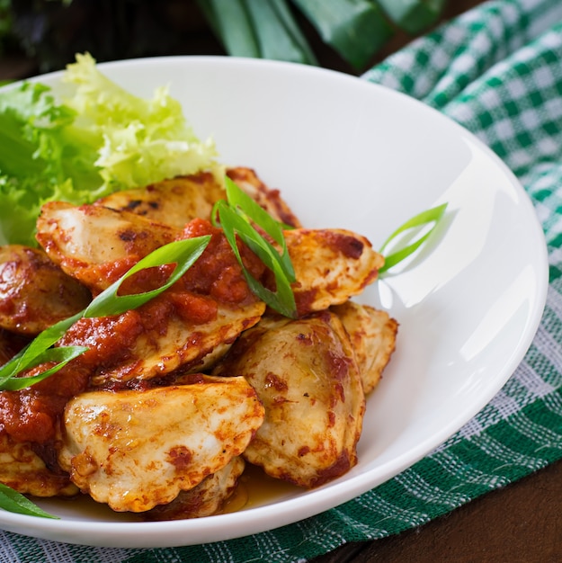 Deliziosi ravioli con salsa di pomodoro e cipolle verdi