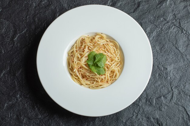 Deliziosi spaghetti con verdure su un piatto bianco.