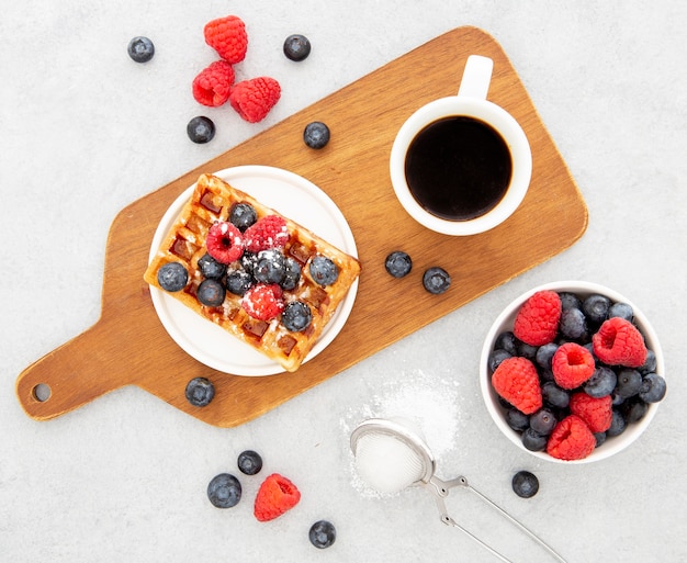 Deliziosi waffle dolci e caffè sul bordo di legno