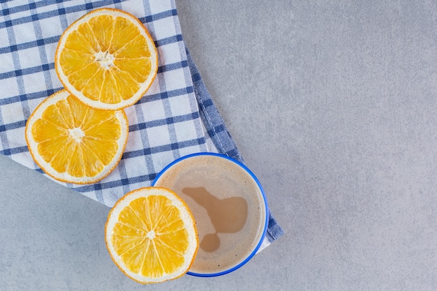 Delizioso caffè caldo e arance a fette sul tavolo di pietra.