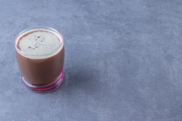 Delizioso caffè in un bicchiere, sullo sfondo blu.