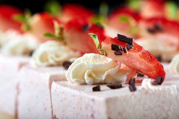 Delizioso dessert del ristorante: soufflé dolce, decorato con fragole fresche, cioccolato grattugiato e panna montata. Buon antipasto per vino leggero e champagne.