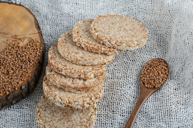 Delizioso pane croccante e cucchiaio di grano saraceno su tela bianca