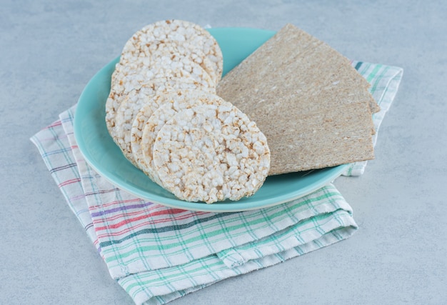 Delizioso pane croccante nel piatto su torre su marmo.