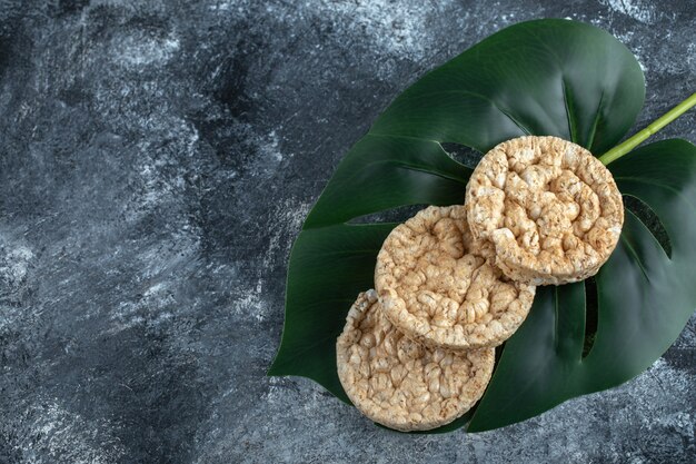 Delizioso pane croccante rotondo su foglie verdi.