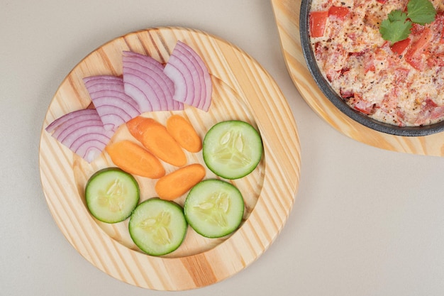 Delizioso pasto con verdure a fette su tavola di legno.