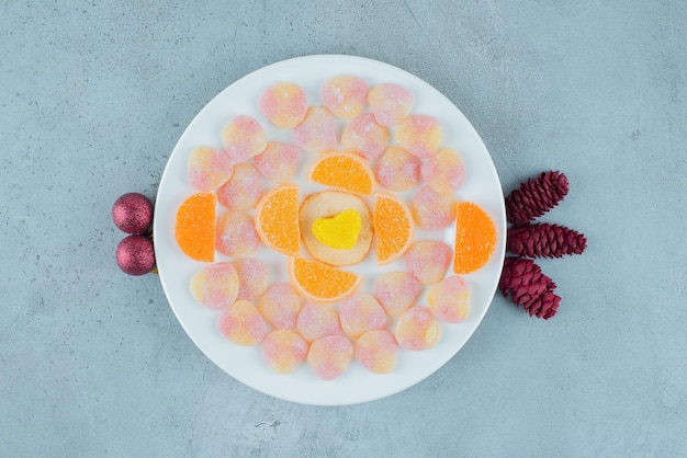 Delizioso piatto di marmellate assortite, con pigne e palline su marmo.