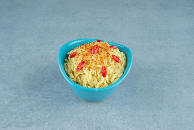Delizioso riso con fette di pomodoro in una ciotola blu.
