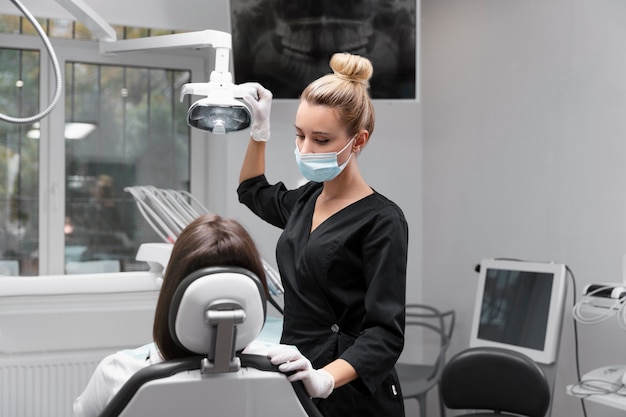 Dentista a colpo medio che indossa una maschera facciale