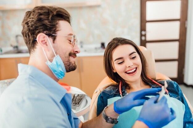 Dentista che abbina il colore dello smalto dei denti con la tabella sbiancante.