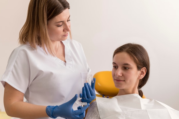 Dentista che controlla la cura mensile del paziente