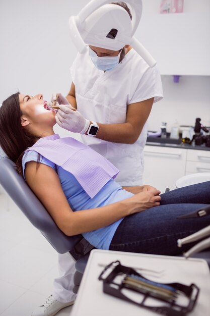 Dentista che esamina i denti pazienti femminili