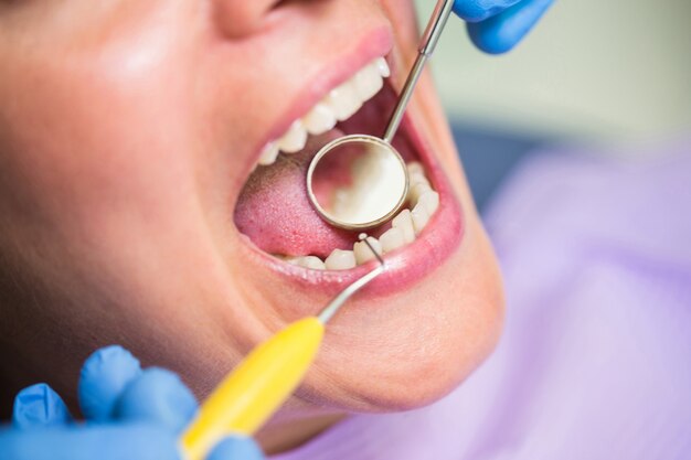 Dentista che esamina i denti pazienti femminili