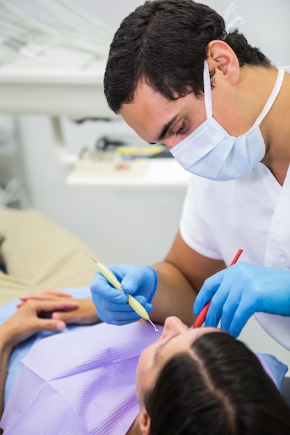 Dentista che fa controllo orale su del paziente femminile