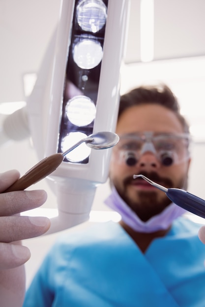 Dentista che tiene gli strumenti dentali