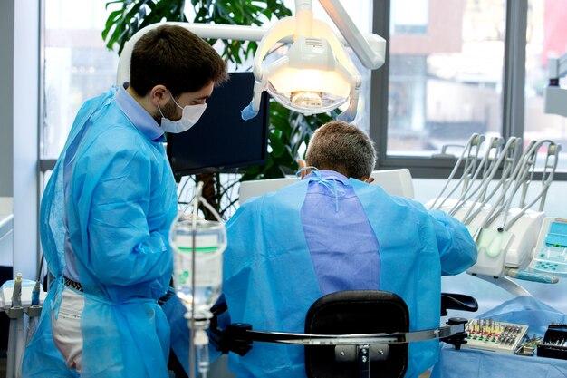 Dentista e assistente mentre si lavora con un paziente