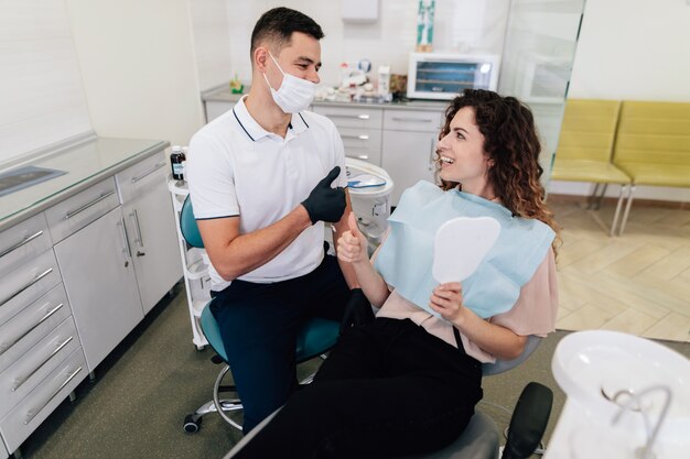 Dentista e paziente felici e sorridenti