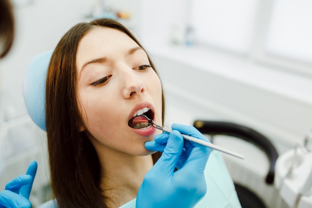 Dentista esaminando denti di giovane donna