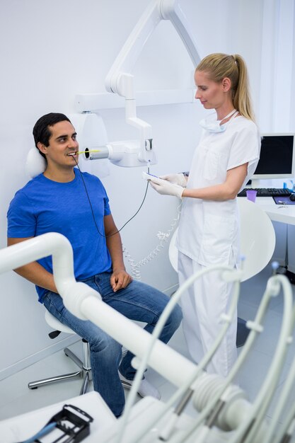 Dentista femminile che cattura raggi x dei denti dei pazienti