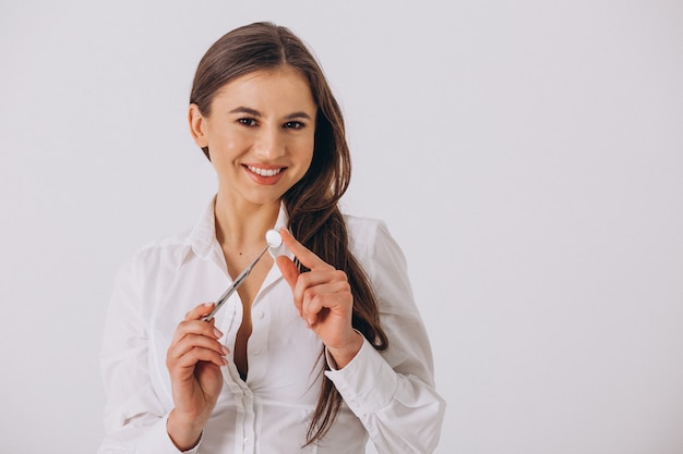 Dentista femminile con gli strumenti di odontoiatria isolati