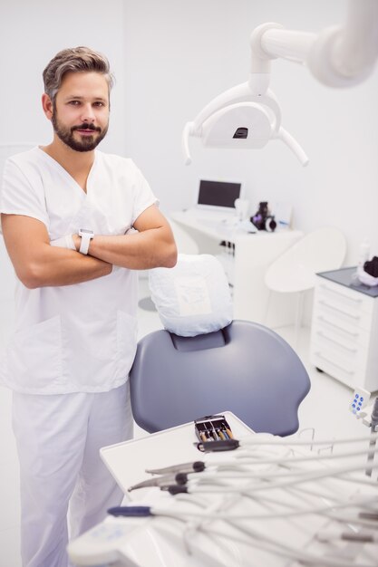 Dentista in piedi con le braccia incrociate