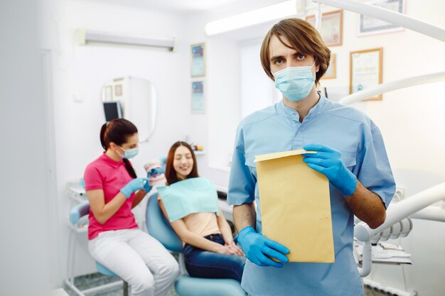 Dentista in possesso di una busta marrone