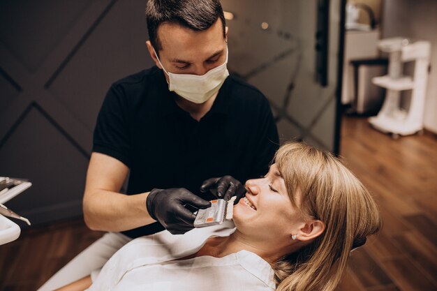 Dentista in visita del paziente della donna