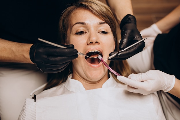 Dentista in visita del paziente della donna