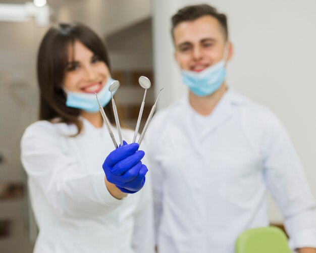 Dentisti sfocati che tengono attrezzatura dentale