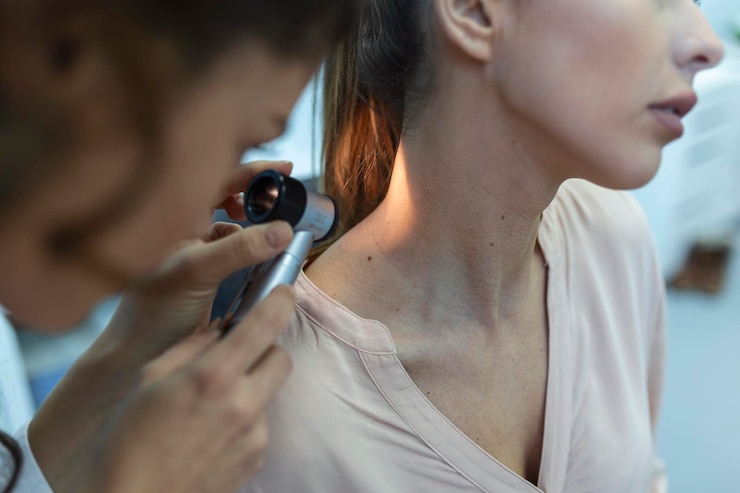 Foto gratuito dermatologo in guanti di lattice che tiene il dermatoscopio mentre esamina un paziente attraente con malattie della pelle dermatologo femminile che esamina il paziente con un dermatoscopio in cerca di segni di cancro della pelle