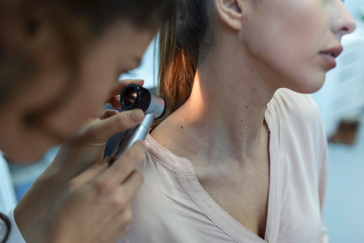 Dermatologo in guanti di lattice che tiene il dermatoscopio mentre esamina un paziente attraente con malattie della pelle Dermatologo femminile che esamina il paziente con un dermatoscopio in cerca di segni di cancro della pelle