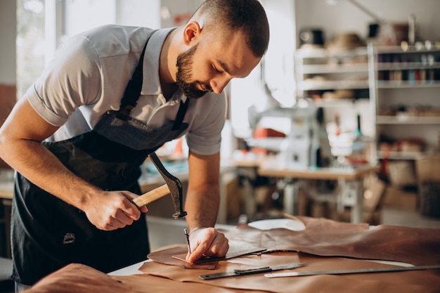 Designer maschio e sarto in pelle che lavora in una fabbrica