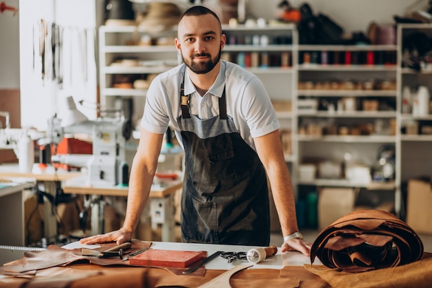 Designer maschio e sarto in pelle che lavora in una fabbrica