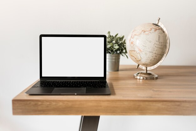 Desktop con portatile e globo terrestre