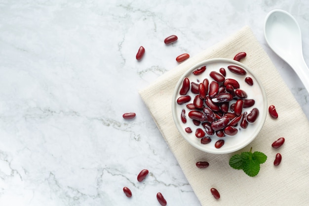 dessert al latte di cocco di fagioli rossi in una ciotola bianca sul pavimento in marmo bianco