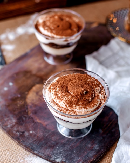 Dessert bianco di vista frontale decorato con cioccolato in polvere sul pavimento marrone