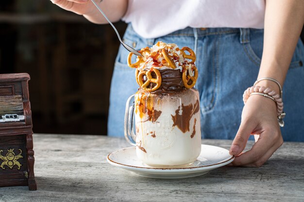 Dessert cremoso con cioccolato e biscotti servito da una donna