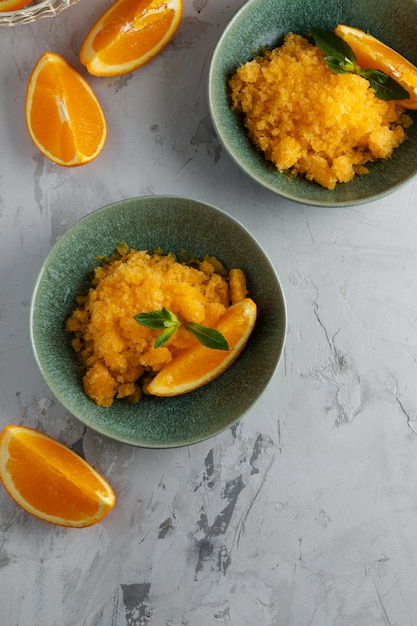 Dessert di granita con natura morta all'arancia piatta